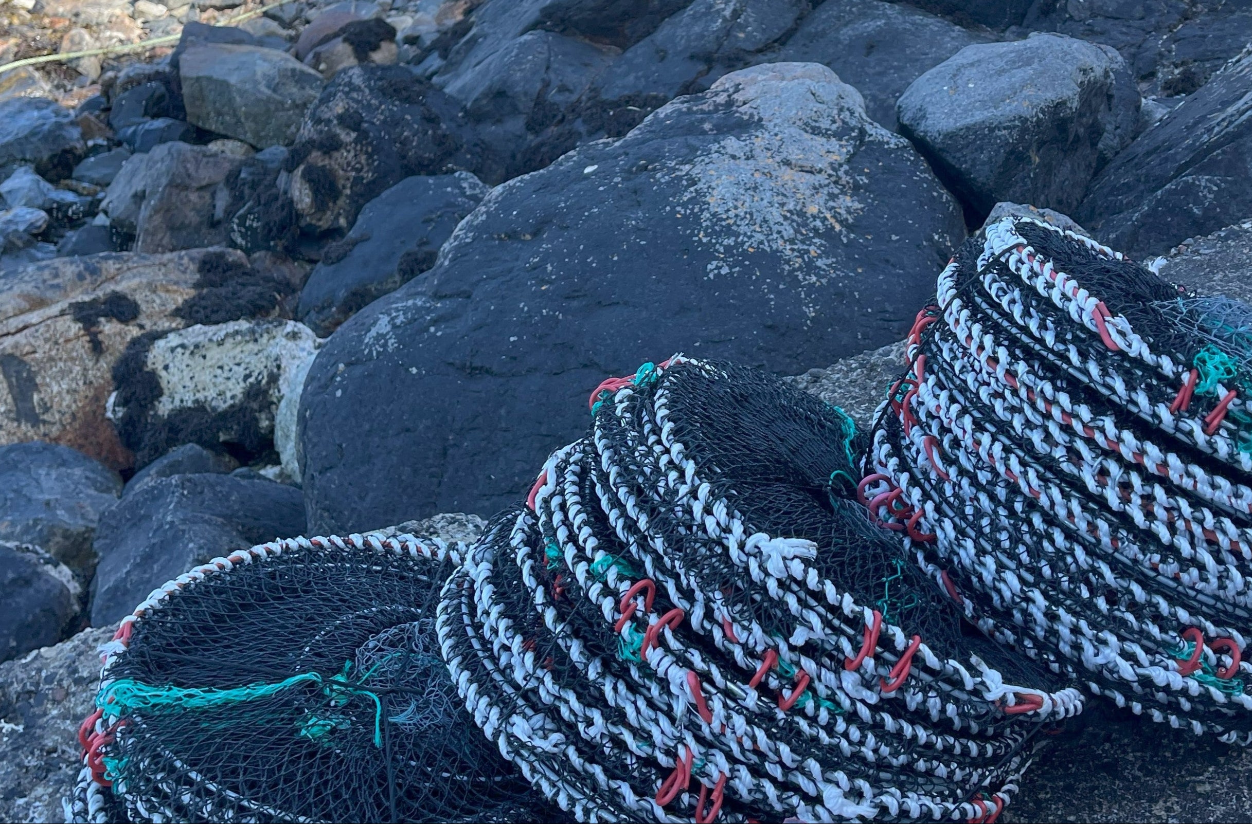 Stack of lobster traps on a rocky surface